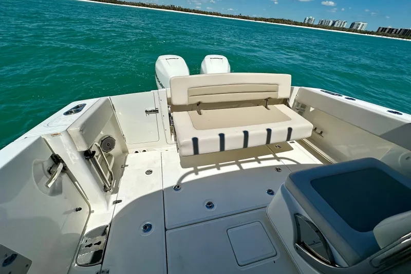 Slide: The Image of 2018 Boston Whaler 320 Vantage boat interior with seating, on clear blue water. - 21