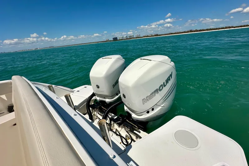 Slide: The Image of 2018 Boston Whaler 320 Vantage with twin Mercury engines on turquoise water. - 22