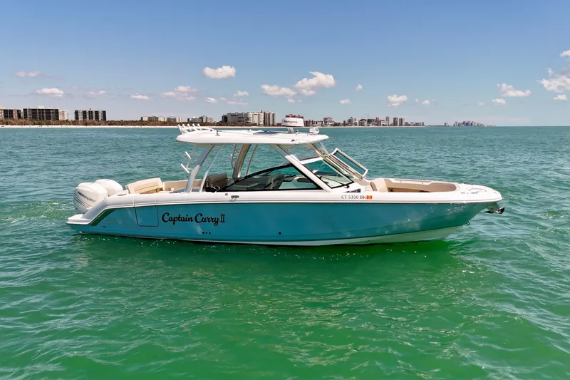 Slide: The Image of 2018 Boston Whaler 320 Vantage boat on turquoise water, city skyline in background. - 25