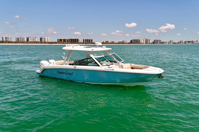 Slide: The Image of 2018 Boston Whaler 320 Vantage boat on turquoise water with city skyline background. - 26