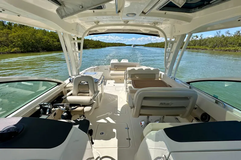 Slide: The Image of 2018 Boston Whaler 320 Vantage cruising on a scenic waterway, showcasing luxurious seating and helm. - 3