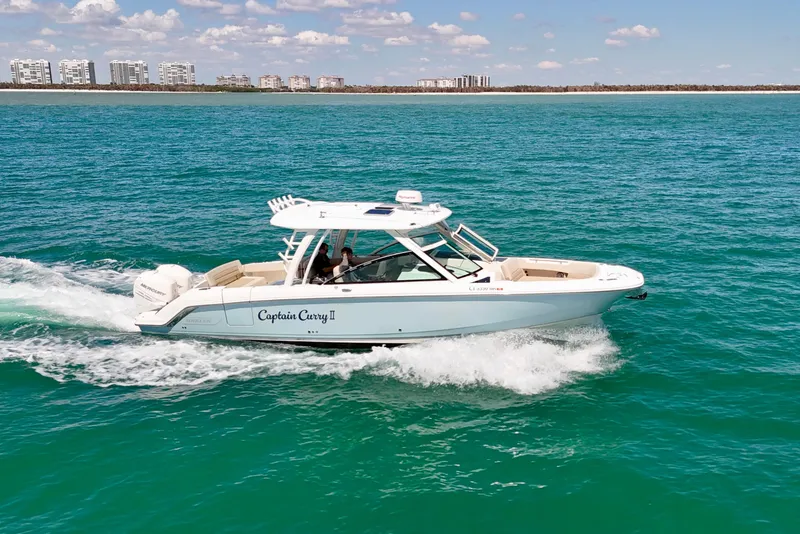 Slide: The Image of 2018 Boston Whaler 320 Vantage cruising on turquoise ocean near city skyline. - 35