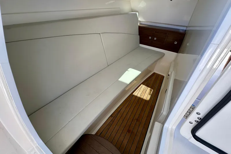 Slide: The Image of Interior of 2018 Boston Whaler 320 Vantage with cushioned seating and wooden flooring. - 7