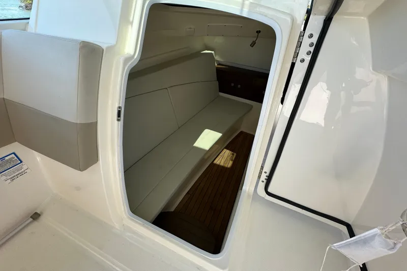 Slide: The Image of 2018 Boston Whaler 320 Vantage cabin interior with seating and wooden flooring. - 8
