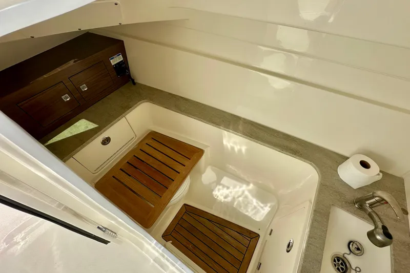 Slide: The Image of 2018 Boston Whaler 320 Vantage interior with wooden accents and sink. - 9
