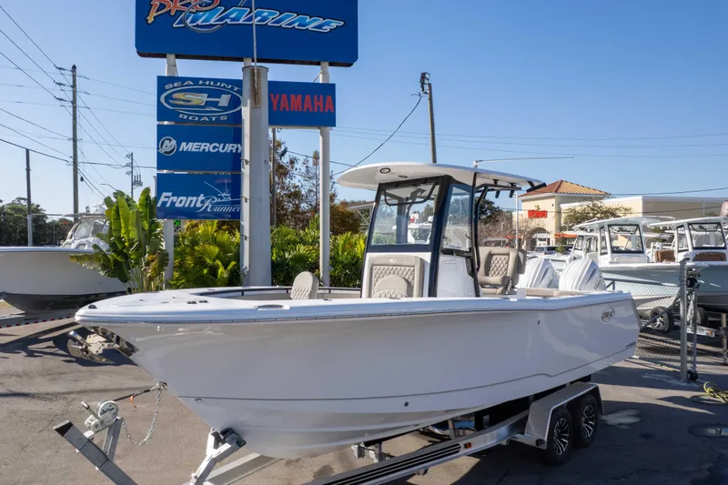 The Image of 2026 Sea Hunt Gamefish 25 boat on trailer at dealership, sunny day. - 1