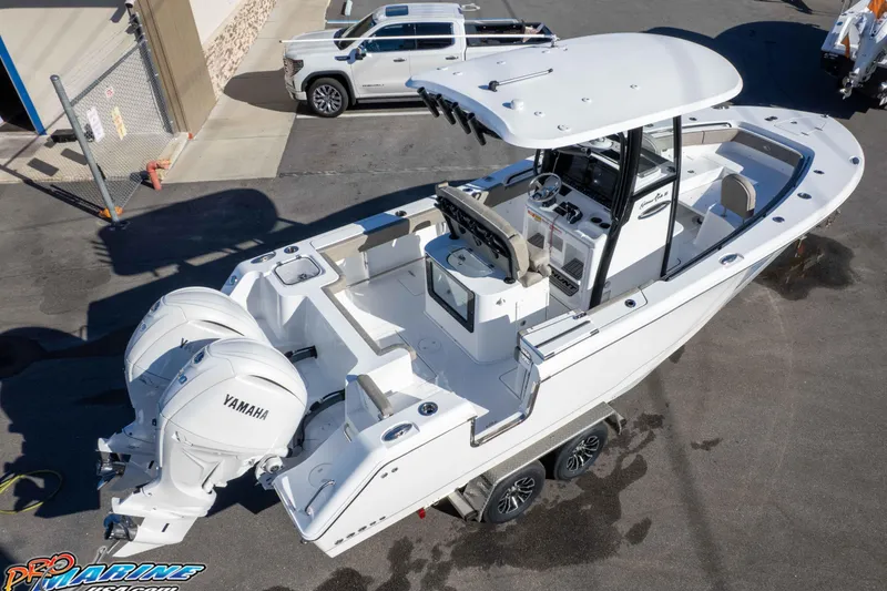 Slide: The Image of 2026 Sea Hunt Gamefish 25 boat with dual Yamaha engines, parked on a trailer. - 18
