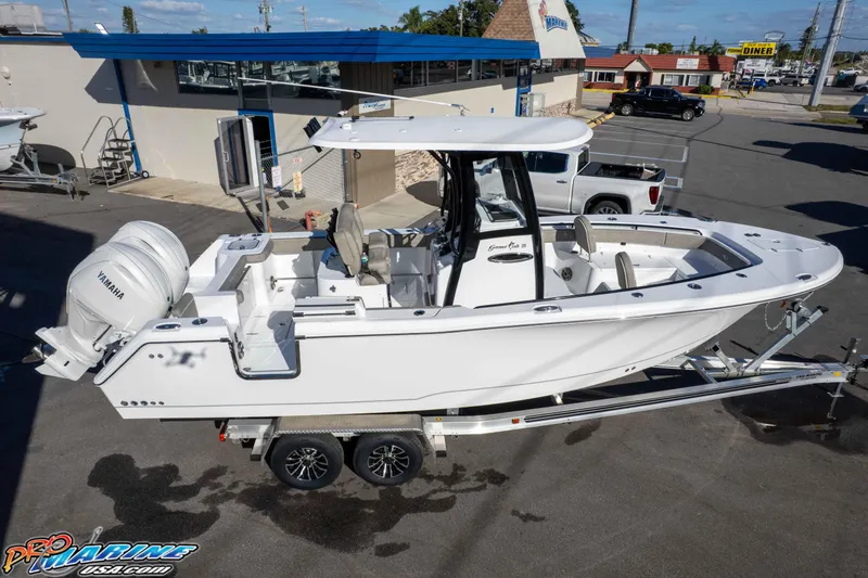 Slide: The Image of 2026 Sea Hunt Gamefish 25 boat on trailer, featuring Yamaha engine, parked outdoors. - 22