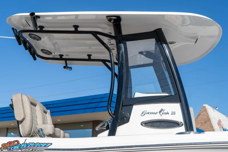 Slide: The Image of 2026 Sea Hunt Gamefish 25 boat with T-top and seating, under clear blue sky. - 42