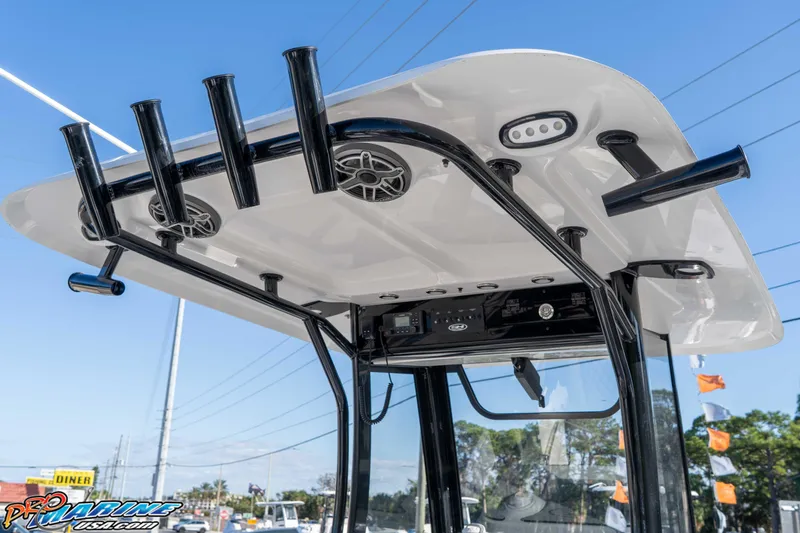 Slide: The Image of 2026 Sea Hunt Gamefish 25 T-top with rod holders and speakers, under clear blue sky. - 47