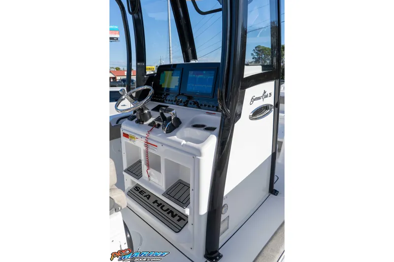 Slide: The Image of 2026 Sea Hunt Gamefish 25 boat console with steering wheel and navigation screens. - 51