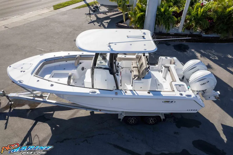 Slide: The Image of 2026 Sea Hunt Gamefish 25 boat with dual Yamaha engines on a trailer. - 6