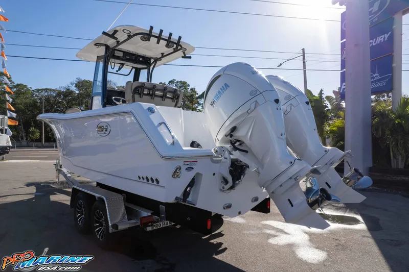 Slide: The Image of 2026 Sea Hunt Gamefish 25 boat with dual Yamaha outboard engines on a trailer. - 7