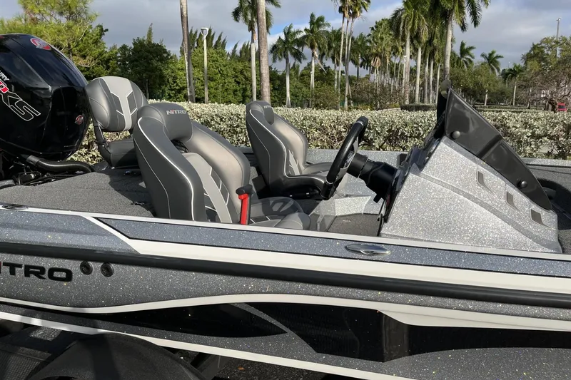 Slide: The Image of 2024 Nitro Z18 boat interior with sleek seats and modern dashboard, surrounded by palm trees. - 10
