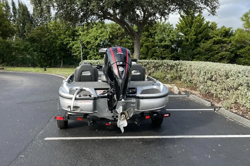 Slide: The Image of 2024 Nitro Z18 boat with outboard motor in a parking lot, surrounded by greenery. - 11