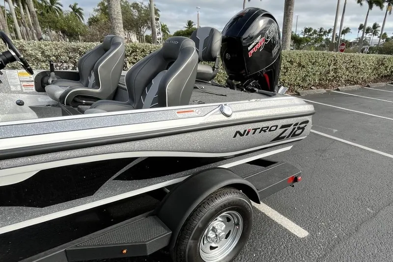 Slide: The Image of 2024 Nitro Z18 boat with sleek design and comfortable seating in a parking lot. - 12