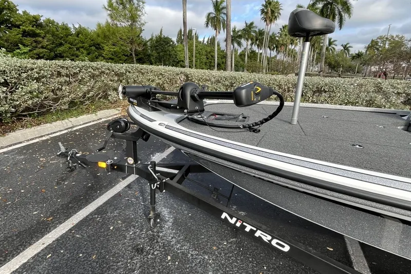 Slide: The Image of 2024 Nitro Z18 boat on trailer in parking lot, surrounded by greenery. - 5