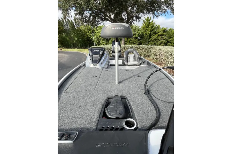Slide: The Image of 2024 Nitro Z18 boat deck with seating and control panel, surrounded by greenery. - 7