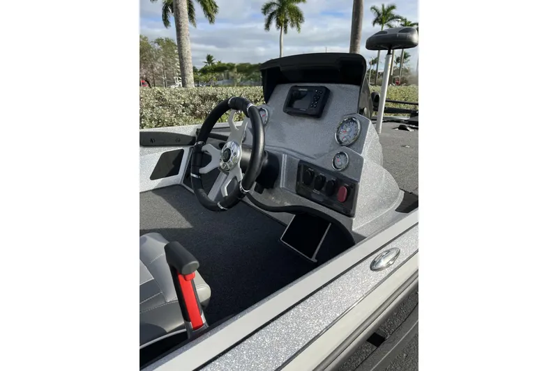 Slide: The Image of 2024 Nitro Z18 boat dashboard with steering wheel and gauges, surrounded by palm trees. - 8