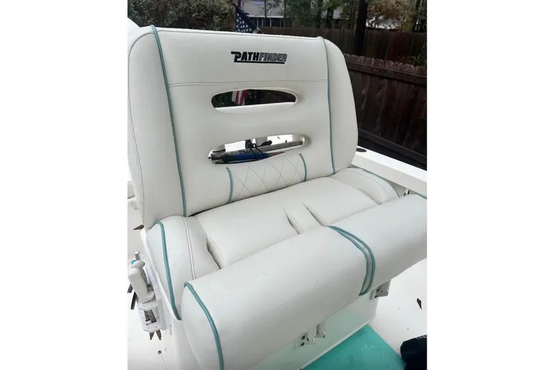 Slide: The Image of 2016 Pathfinder 2600 HPS boat seat with white upholstery and teal accents. - 13