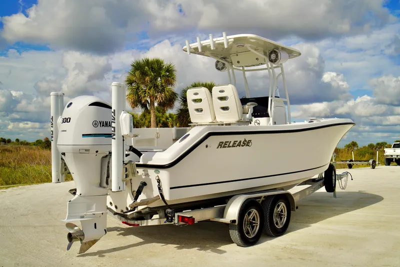 The Image of 2017 Release 240 RX boat on trailer with Yamaha engine, parked outdoors under cloudy sky. - 0