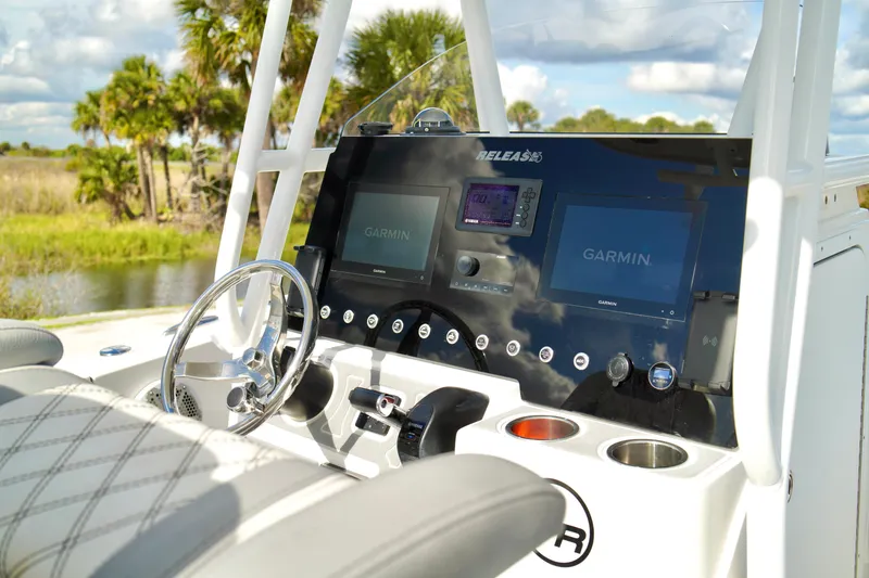 Slide: The Image of 2017 Release 240 RX boat dashboard with Garmin displays and steering wheel. - 14