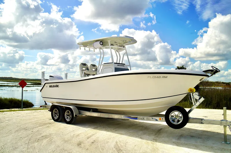 Slide: The Image of 2017 Release 240 RX boat on trailer by a scenic lake under cloudy sky. - 2