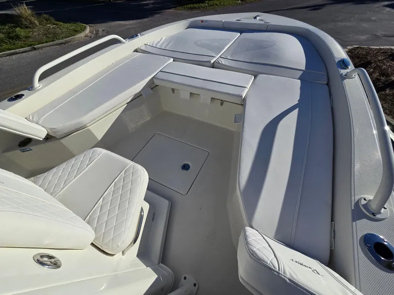 Slide: The Image of 2025 Ranger 2360 Bay boat interior with white cushioned seating and storage compartments. - 6
