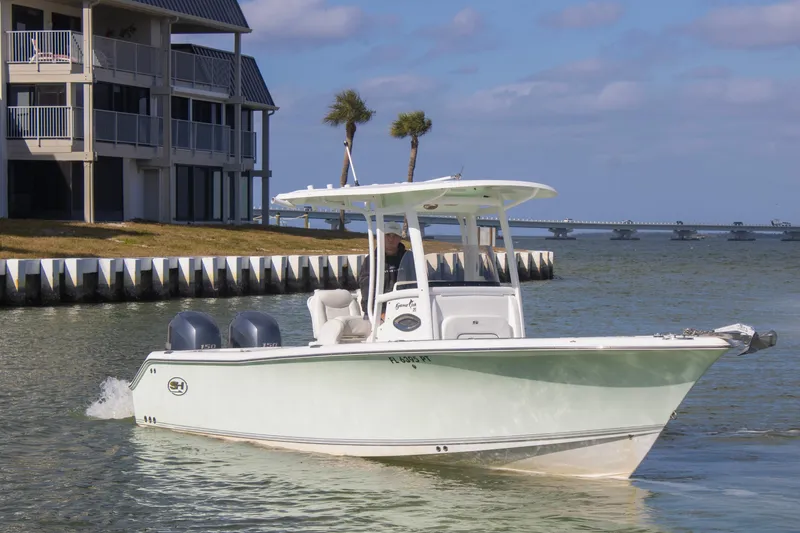 The Image of 2014 Sea Hunt Gamefish 25 boat cruising near waterfront homes and bridge. - 0