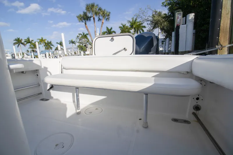 Slide: The Image of 2014 Sea Hunt Gamefish 25 boat interior with white seating and palm trees in background. - 15