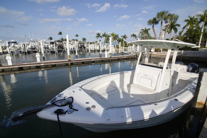 Slide: The Image of 2014 Sea Hunt Gamefish 25 boat docked at a marina with palm trees. - 17