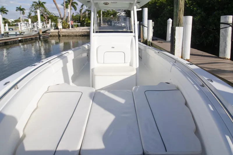Slide: The Image of 2014 Sea Hunt Gamefish 25 boat interior with white seating and dockside view. - 5