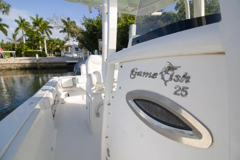 Slide: The Image of 2014 Sea Hunt Gamefish 25 boat docked near lush greenery. - 6