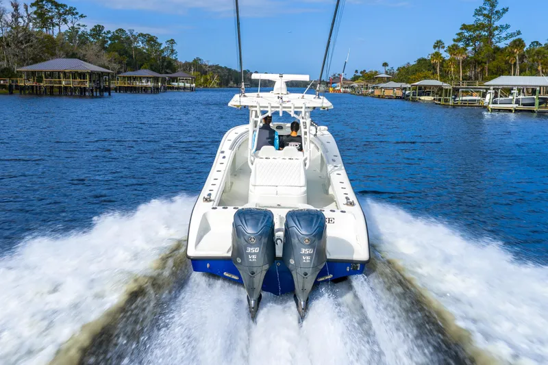 Slide: The Image of 2014 Yellowfin 32 Offshore boat cruising on a scenic waterway with dual engines. - 10