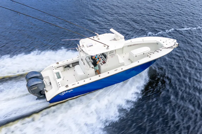 Slide: The Image of 2014 Yellowfin 32 Offshore boat cruising on open water, featuring dual outboard engines. - 12