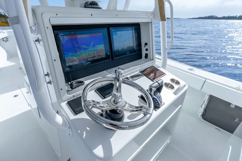 Slide: The Image of 2014 Yellowfin 32 Offshore boat helm with dual displays and steering wheel. - 23