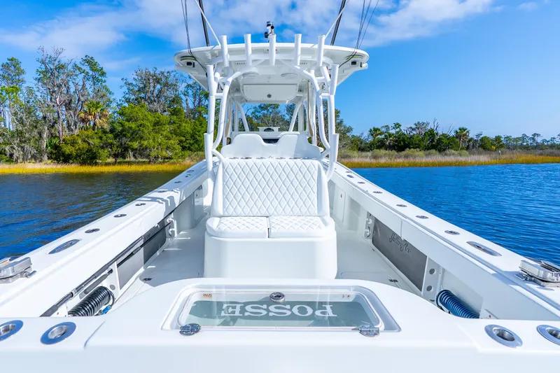Slide: The Image of 2014 Yellowfin 32 Offshore boat on calm water, featuring sleek white design and spacious seating. - 31