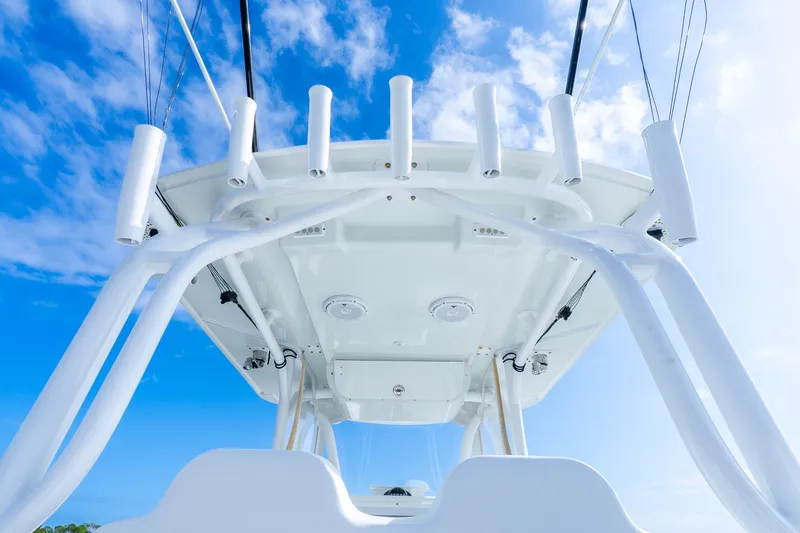 Slide: The Image of 2014 Yellowfin 32 Offshore boat, view of T-top and rod holders against blue sky. - 32