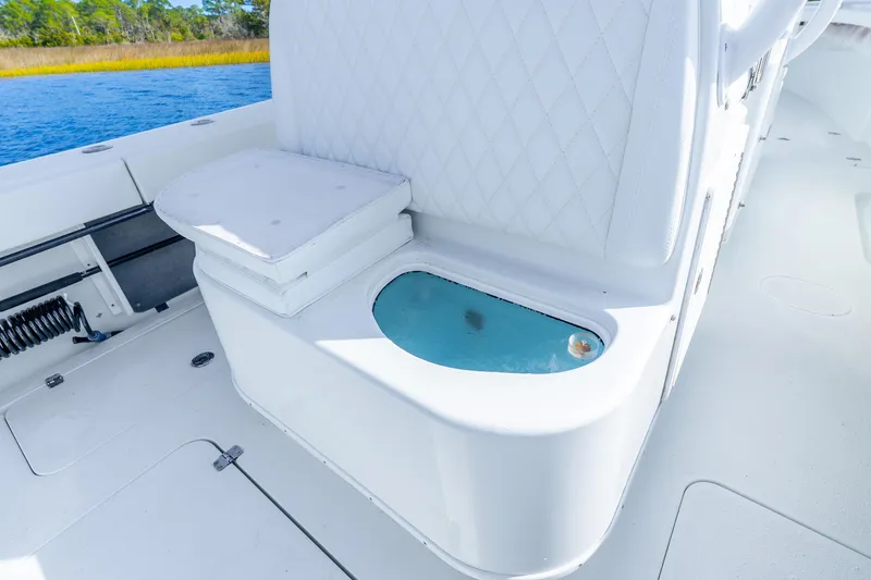 Slide: The Image of 2014 Yellowfin 32 Offshore boat interior with cushioned seating and livewell. - 33