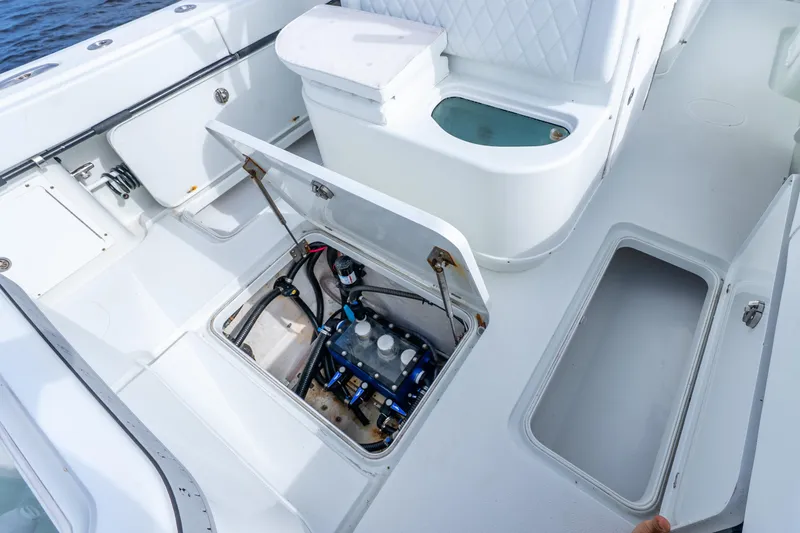 Slide: The Image of 2014 Yellowfin 32 Offshore boat interior with open storage compartments and seating. - 34