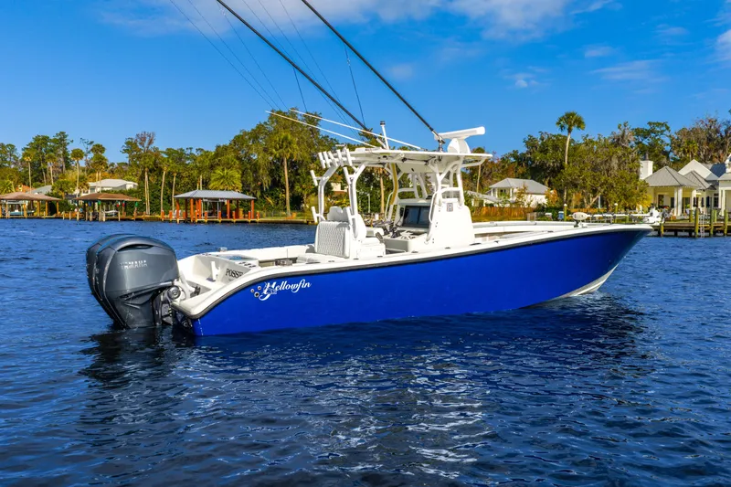 Slide: The Image of 2014 Yellowfin 32 Offshore boat on water, blue hull, twin Yamaha engines. - 4