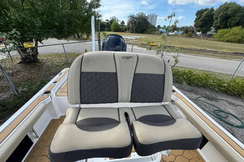 Slide: The Image of 2022 Tidewater 2300 Carolina Bay boat with cushioned seating, parked outdoors. - 10