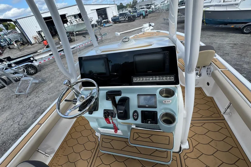 Slide: The Image of 2022 Tidewater 2300 Carolina Bay boat console with steering wheel and navigation displays. - 11