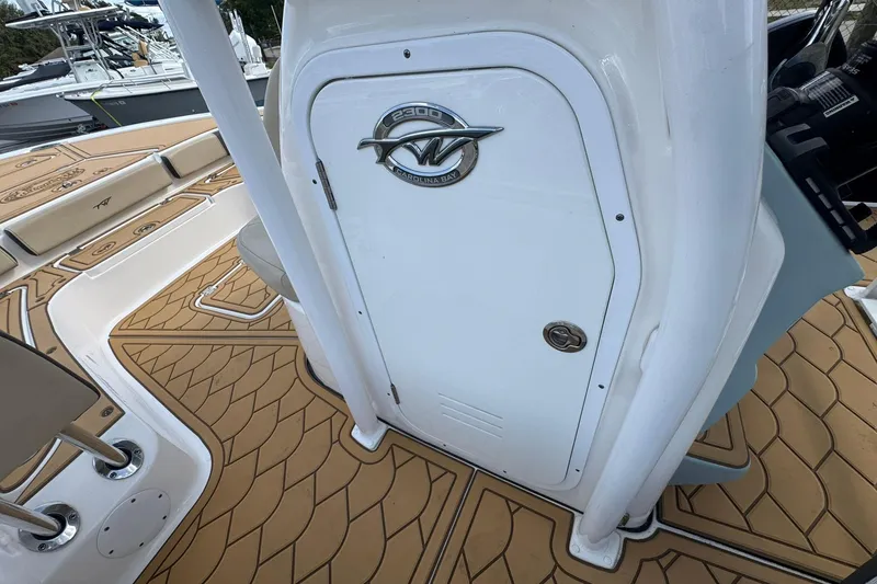 Slide: The Image of 2022 Tidewater 2300 Carolina Bay boat interior with tan deck and storage compartment. - 19