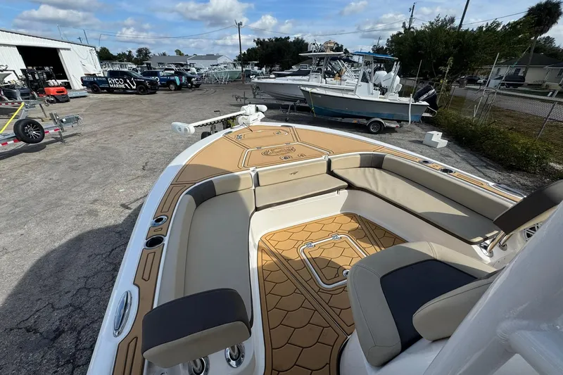 Slide: The Image of 2022 Tidewater 2300 Carolina Bay boat with tan seating and deck, parked outdoors. - 21