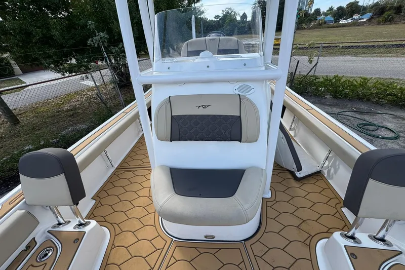 Slide: The Image of 2022 Tidewater 2300 Carolina Bay boat interior with cushioned seating and tan flooring. - 22