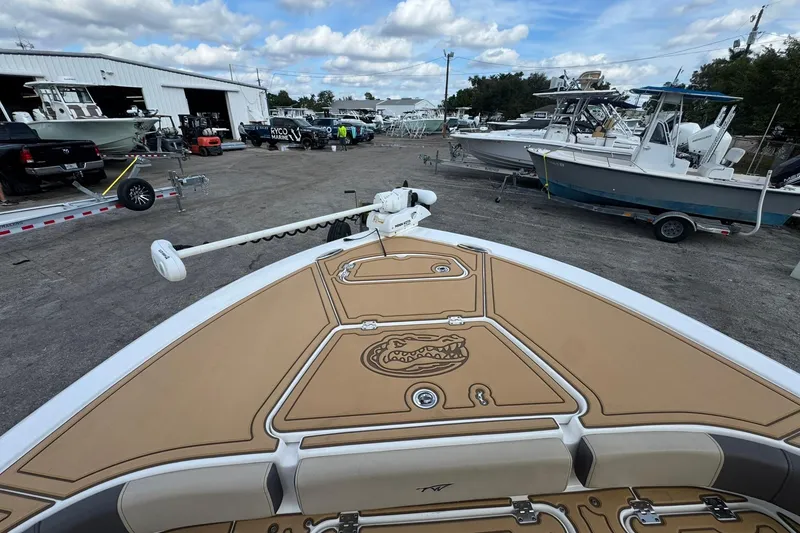 Slide: The Image of 2022 Tidewater 2300 Carolina Bay boat at a marina with other vessels. - 24