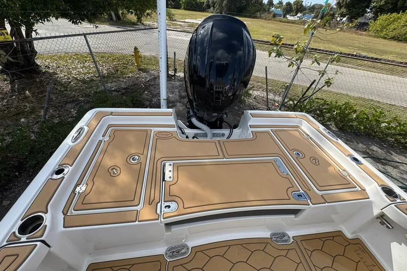 Slide: The Image of 2022 Tidewater 2300 Carolina Bay boat with tan deck and powerful outboard motor. - 5