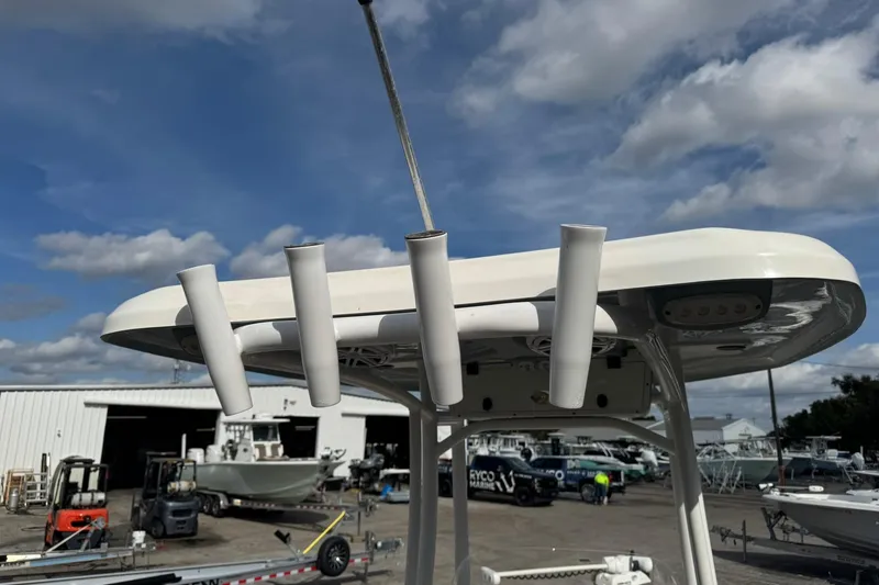 Slide: The Image of 2022 Tidewater 2300 Carolina Bay boat with rod holders, docked under a cloudy sky. - 8