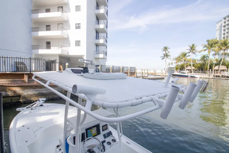 Slide: The Image of 2014 Yellowfin 24 Bay boat docked near waterfront buildings and palm trees. - 15